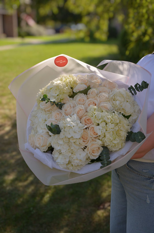 A bouquet of beige roses and white hydrangeas.