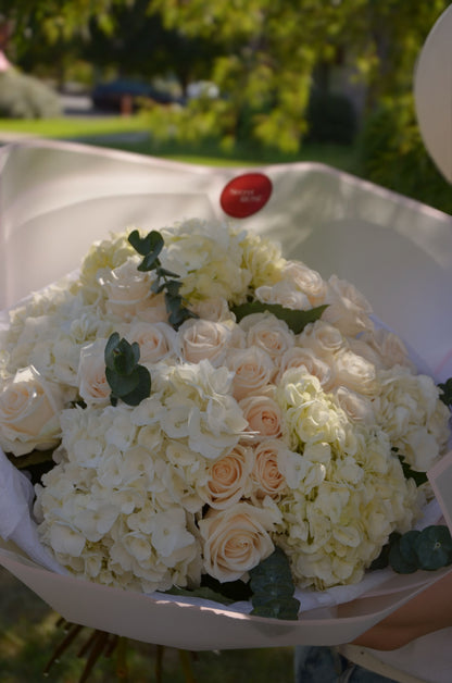 A bouquet of beige roses and white hydrangeas.